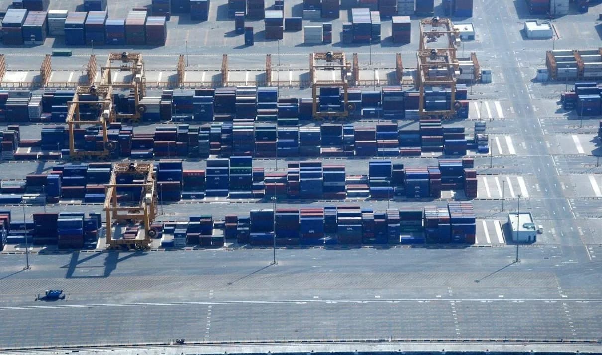 Aerial view of stacked containers and gantry cranes in the container yard at Jebel Ali Port