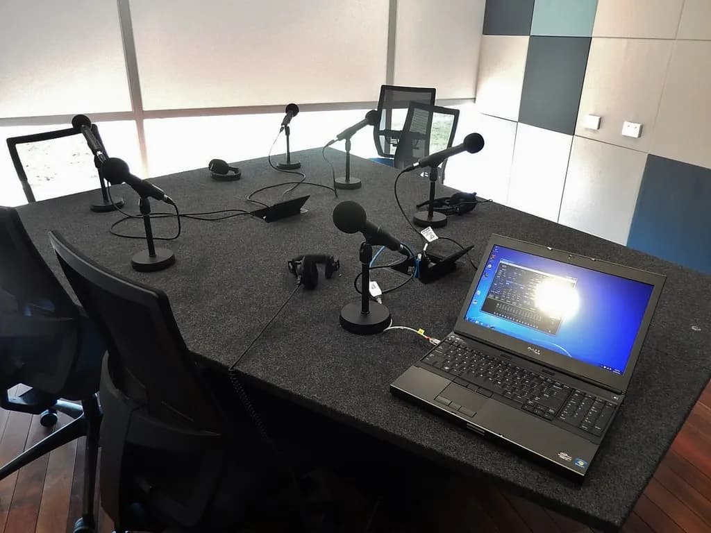 A small podcast studio with microphones and a mixing desk