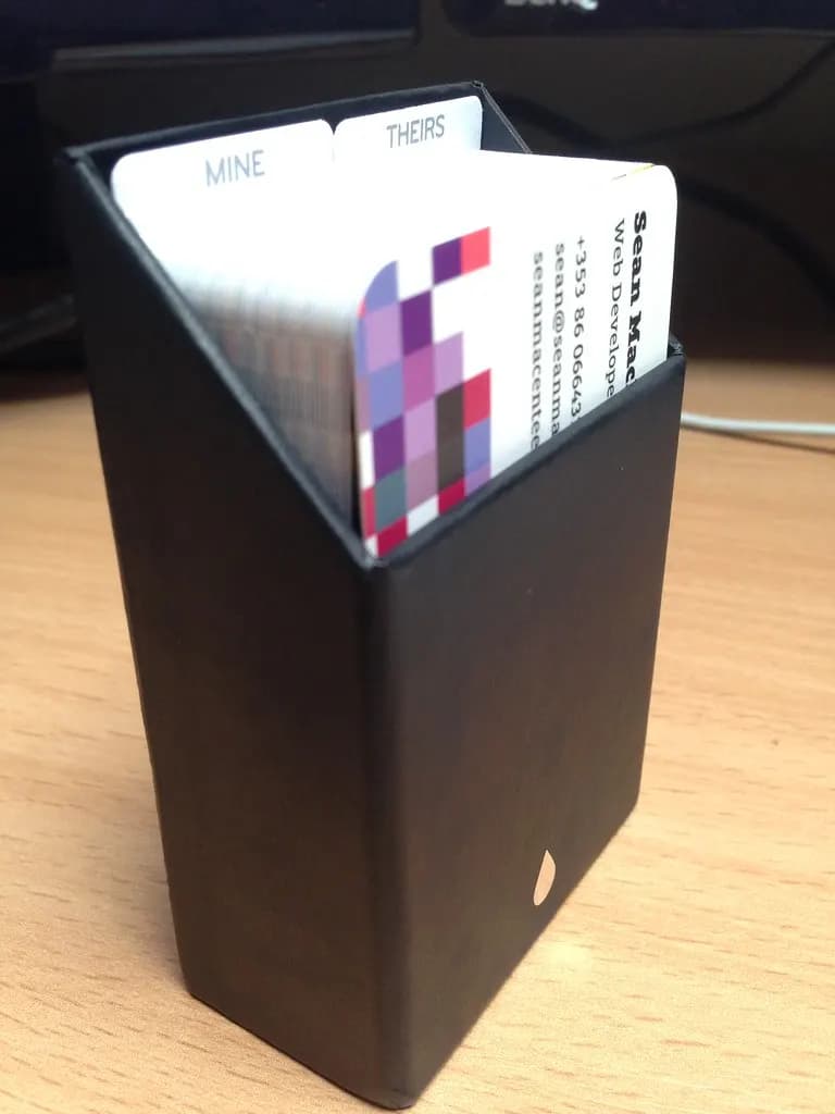 Stack of business cards in a black desk holder
