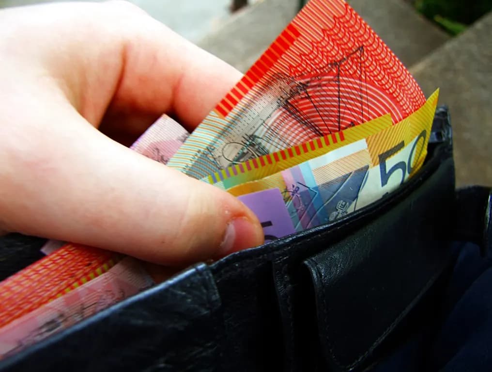 Australian banknotes tucked into a leather wallet