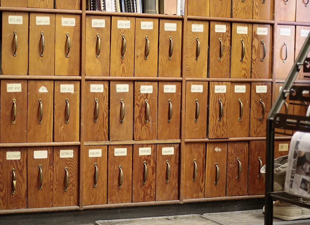 Wall of labelled wooden filing drawers in an office