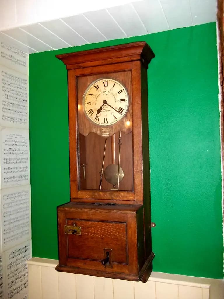 An antique wooden time recorder clock used to record workers' start and finish times