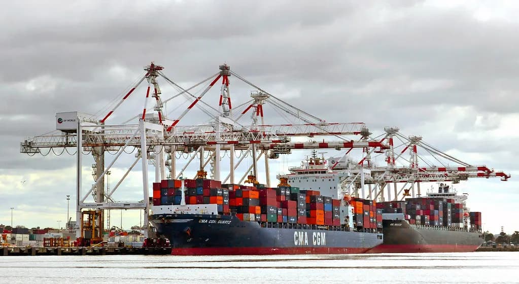 Container ships being loaded under gantry cranes at a container terminal in the Port of Melbourne