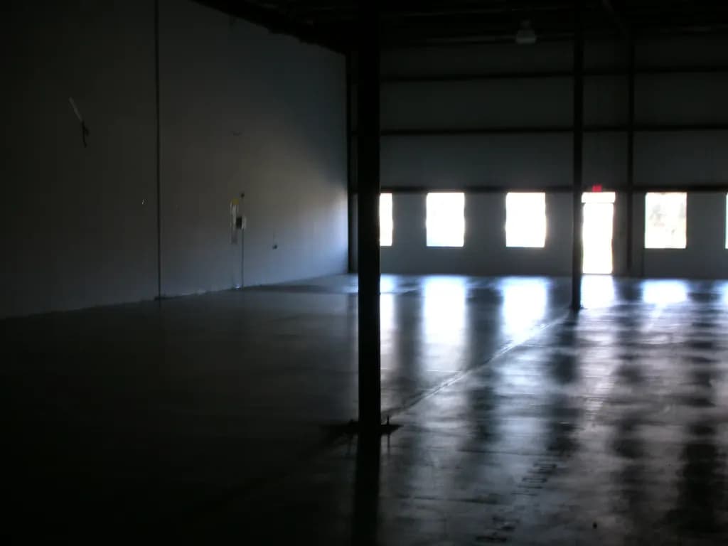 Empty warehouse floor with light coming through the roller-door windows