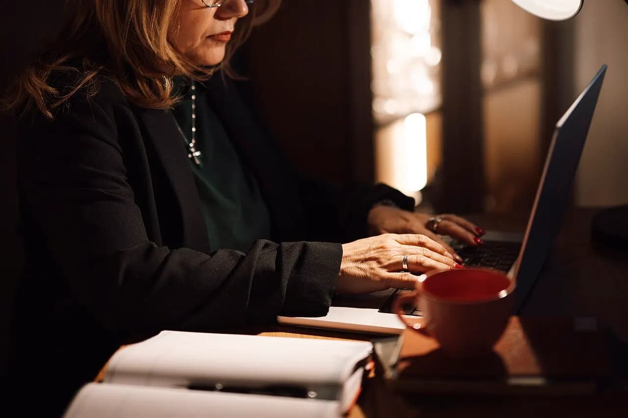 A self-employed businesswoman typing on a laptop in her home office