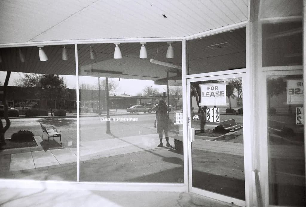 Empty storefront window with a For Lease sign