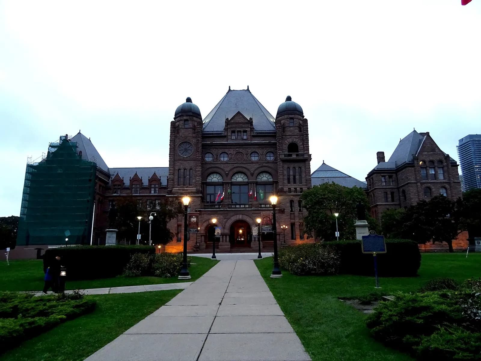 The Ontario Legislative Building at Queen's Park, Toronto, at dusk with lamps lit along the front walk