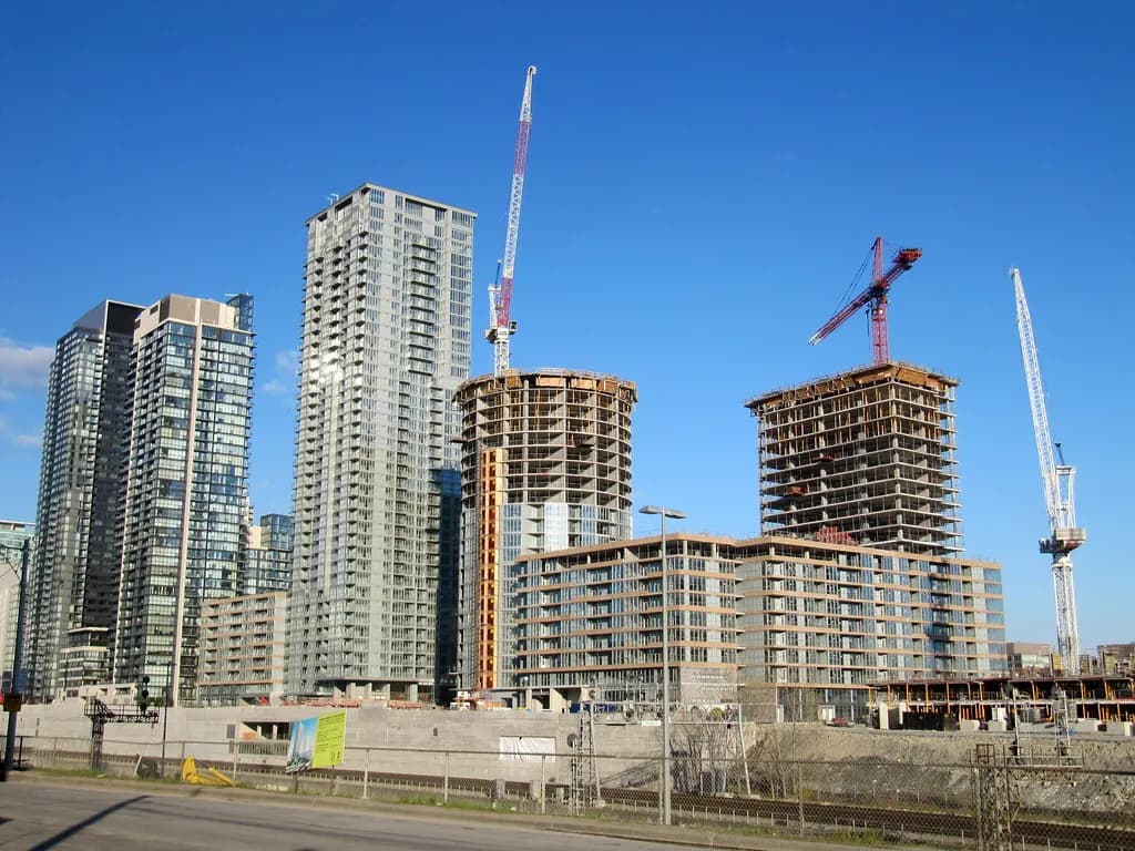 Condominium towers and construction cranes rising over a Toronto building site