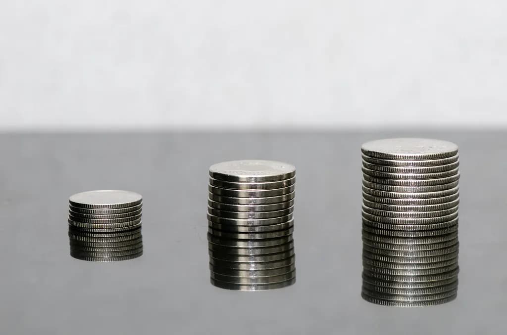 Three stacks of Canadian coins of increasing height on a grey table