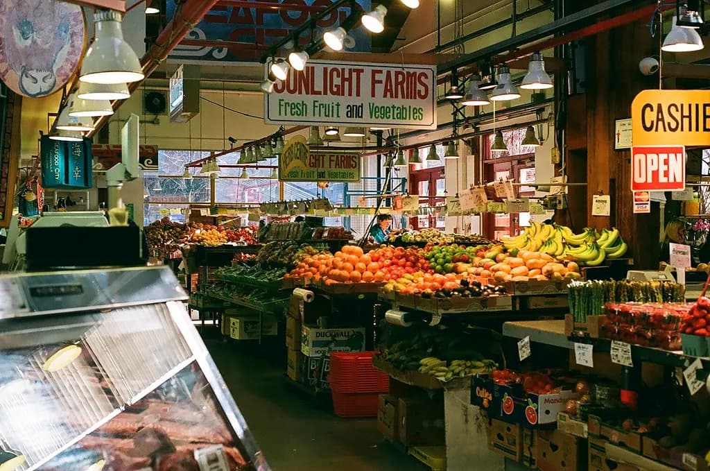 Shoppers among produce and food stalls inside Granville Island Public Market in Vancouver
