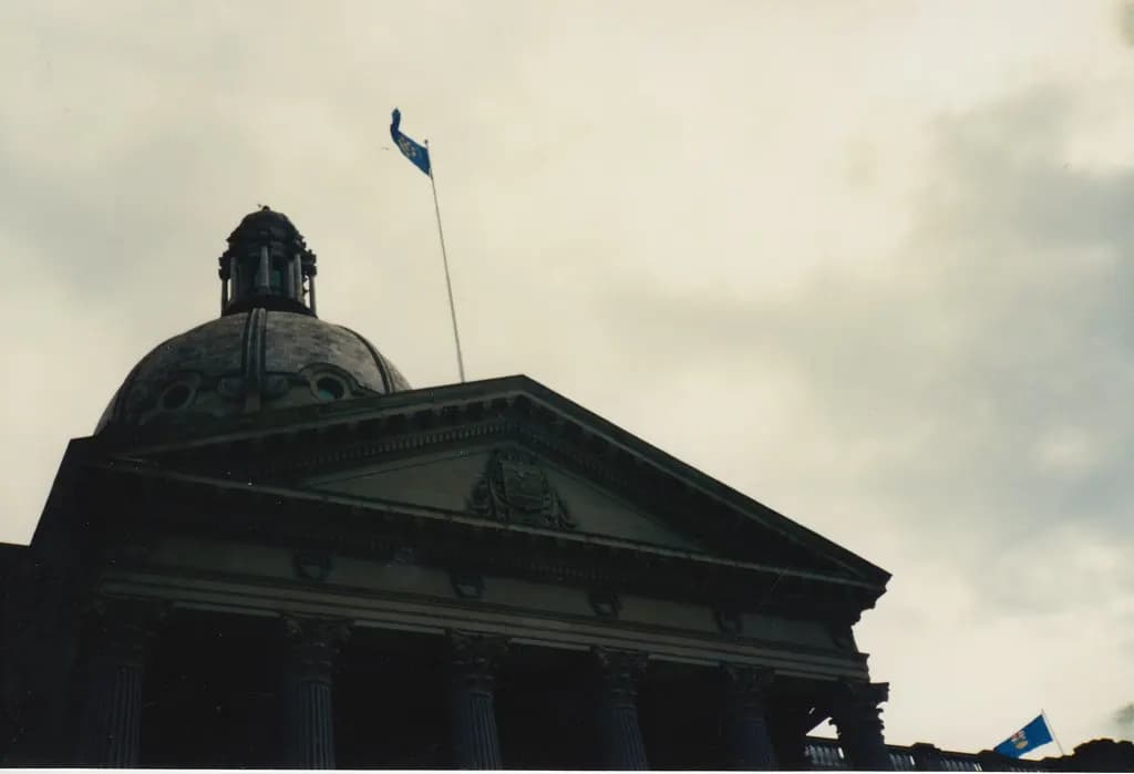 The dome and pediment of the Alberta Legislature Building in Edmonton, with the Alberta flag flying above