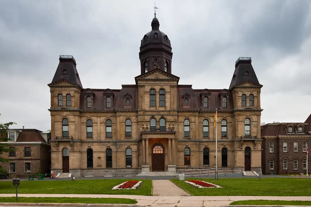 The New Brunswick Legislative Building in Fredericton, a Second Empire stone building with a central dome and flag