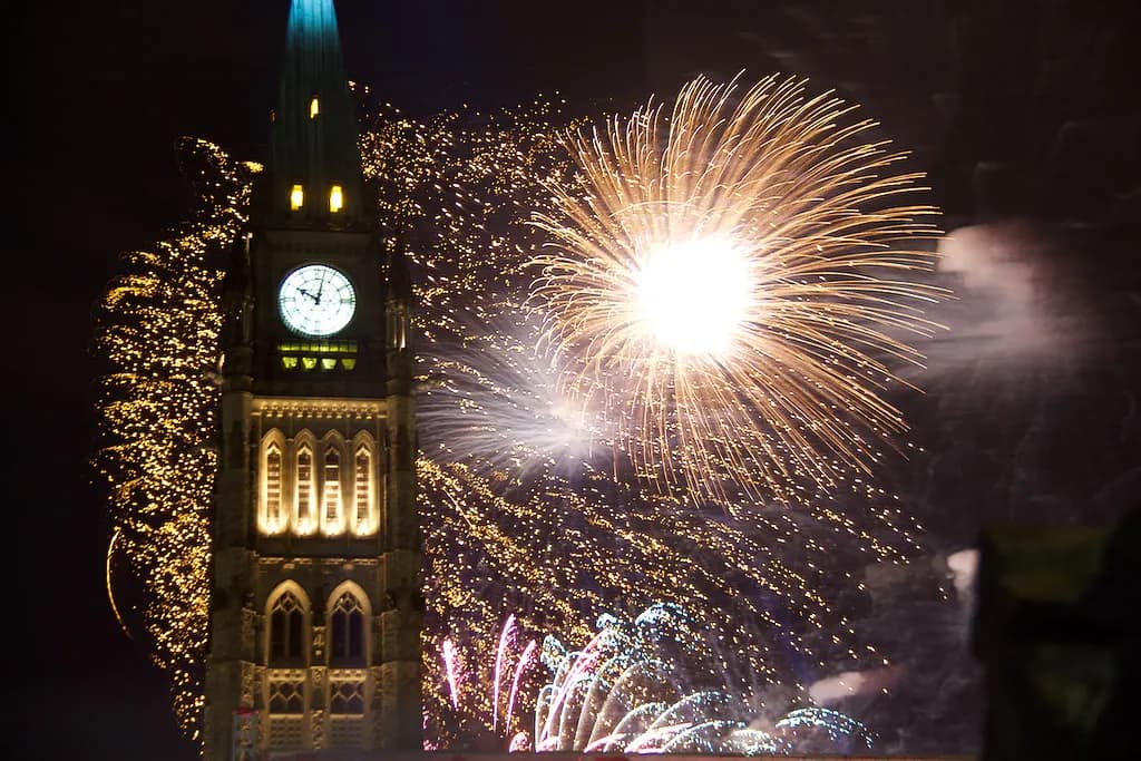 Fireworks bursting beside the Peace Tower on Parliament Hill in Ottawa at night