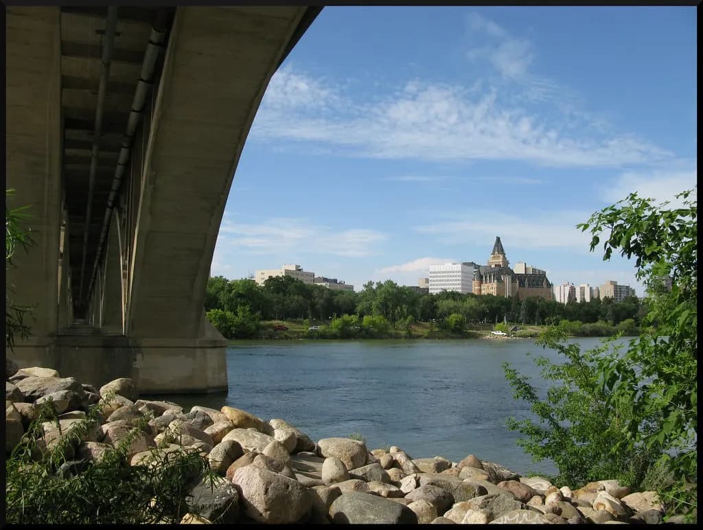 Downtown Saskatoon and the South Saskatchewan River seen from beneath a bridge arch