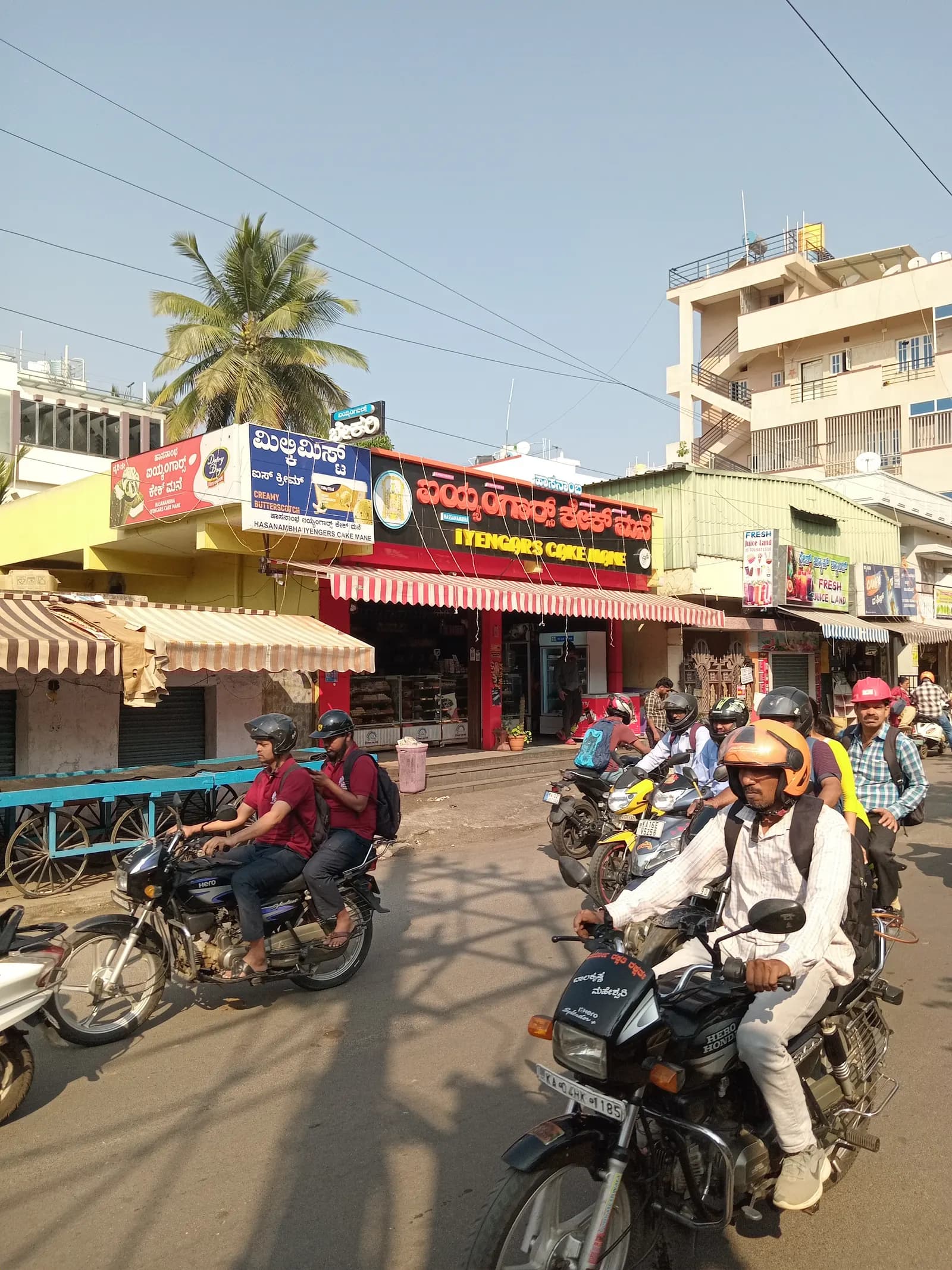 Roadside Iyengar Bakery shopfront in Dasarahalli, Bangalore, with its signboard above the counter and two-wheelers parked outside