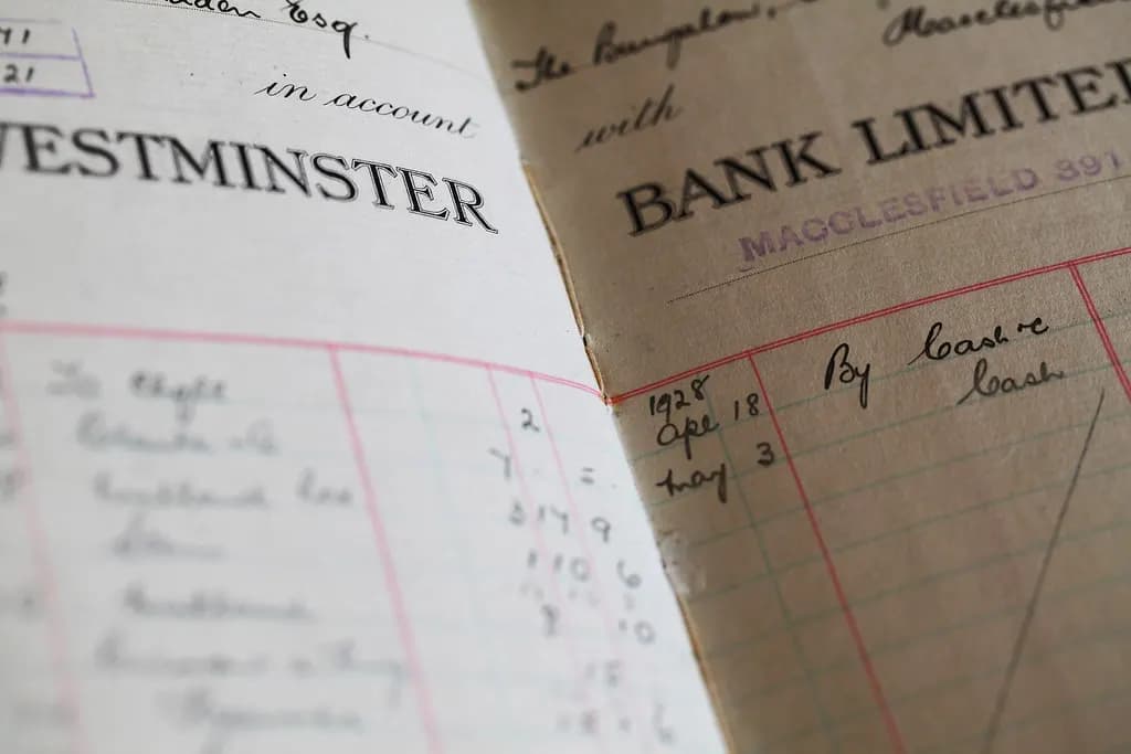 An old handwritten bank ledger book open on a desk