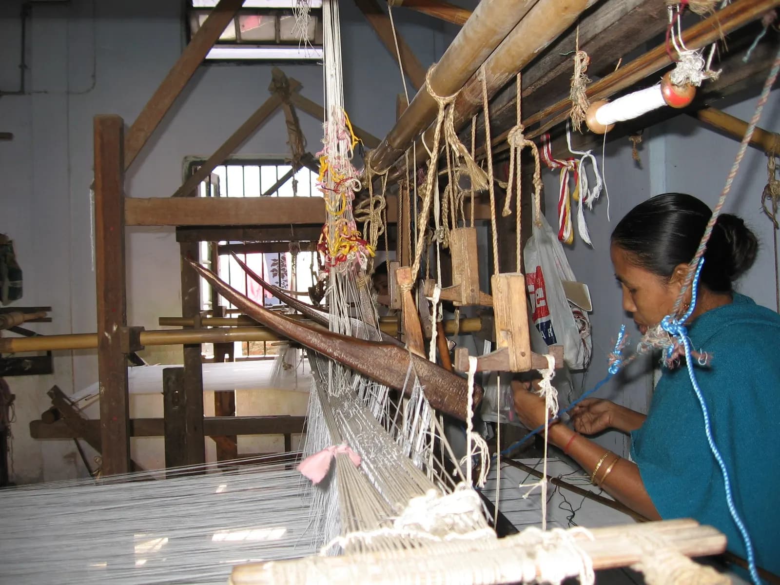 A woman weaving on a traditional wooden handloom in a Mahila Samiti workshop in Tezpur, Assam