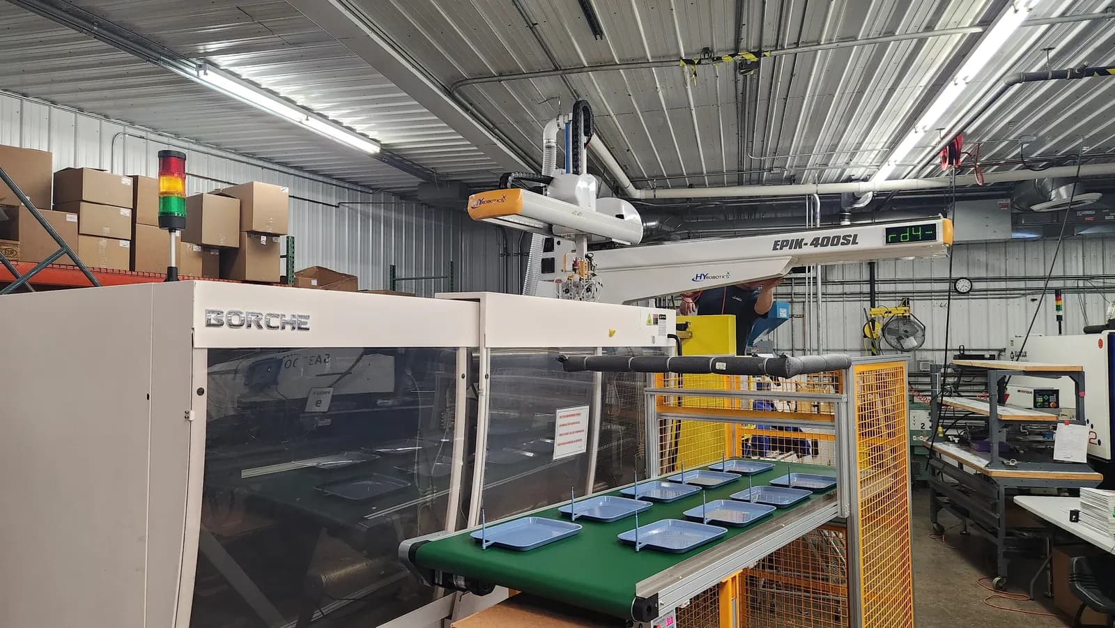 An injection moulding machine with a robot arm that removes moulded plastic parts