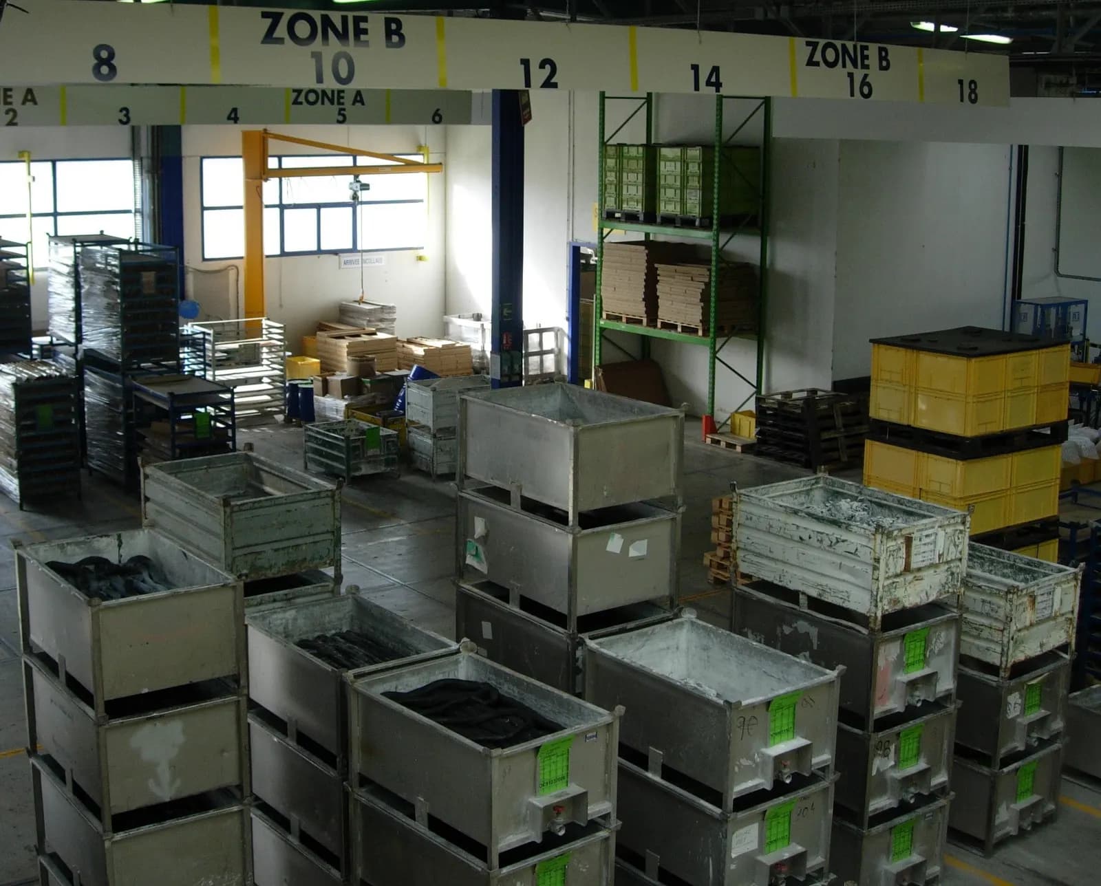 Crates of moulded plastic parts stacked in a plastics processing plant's storage area