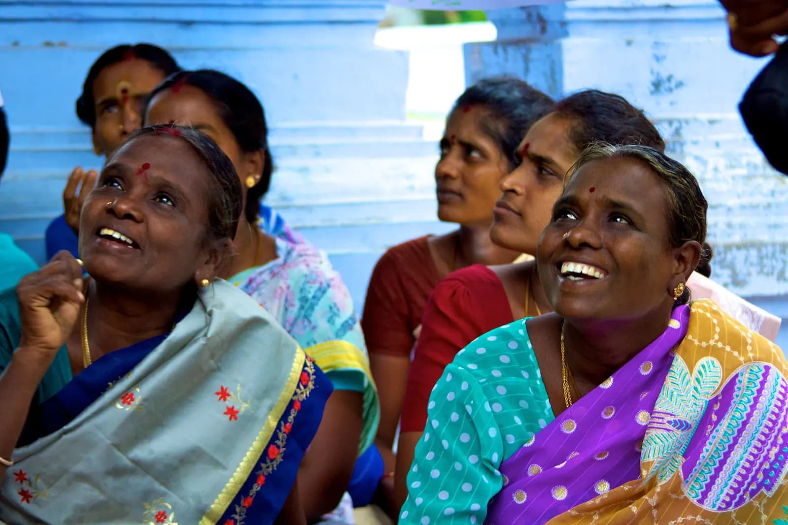 Women from a self-help group listening during a basic business training session in India