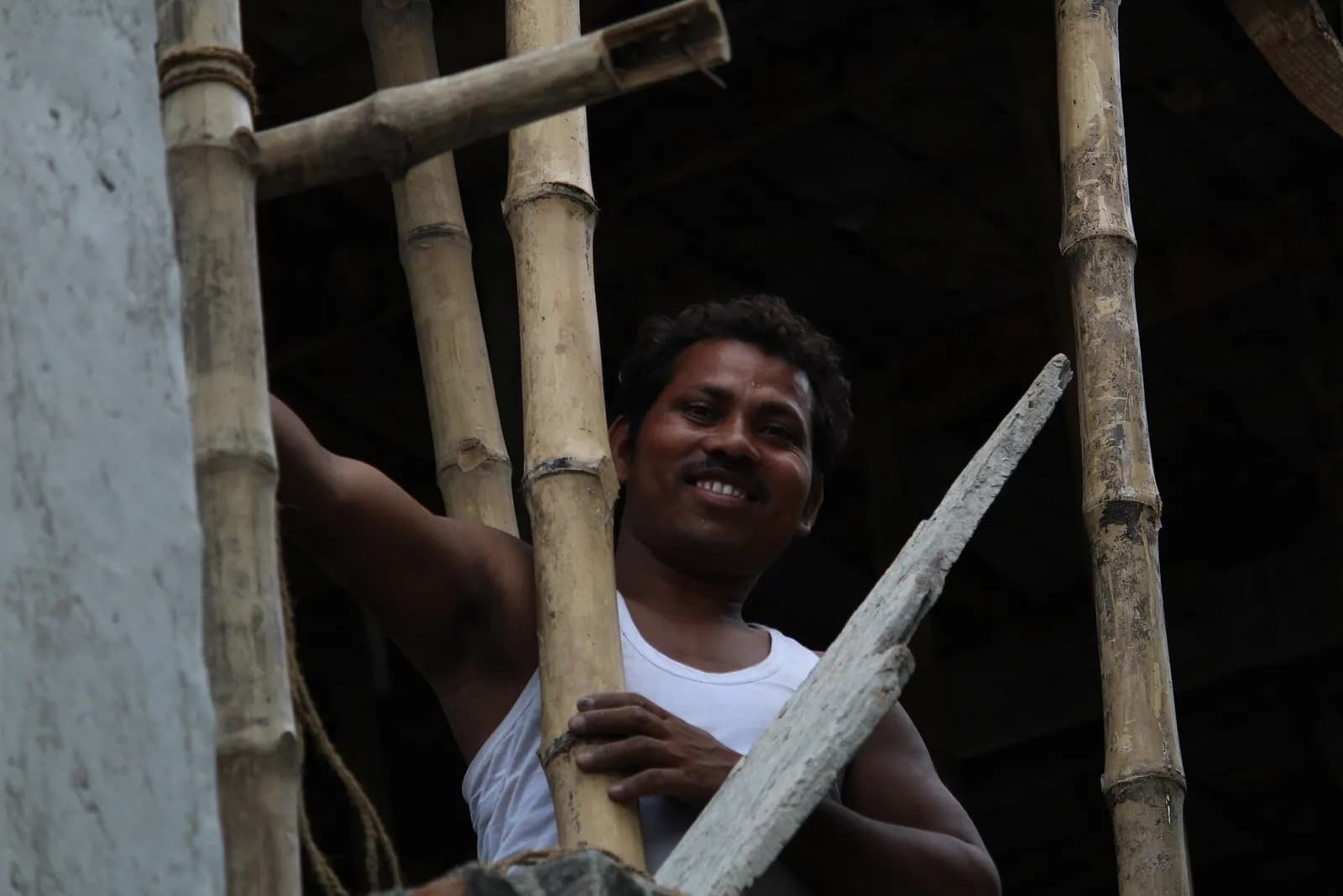 A construction worker on bamboo scaffolding at a building site in India