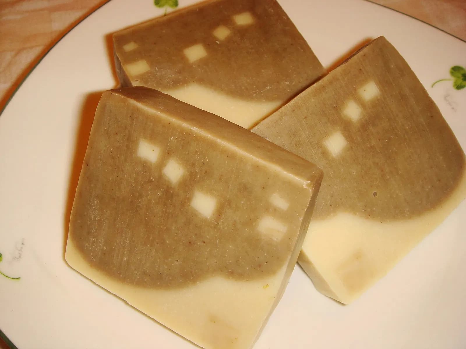 Three handmade soap bars on a white plate