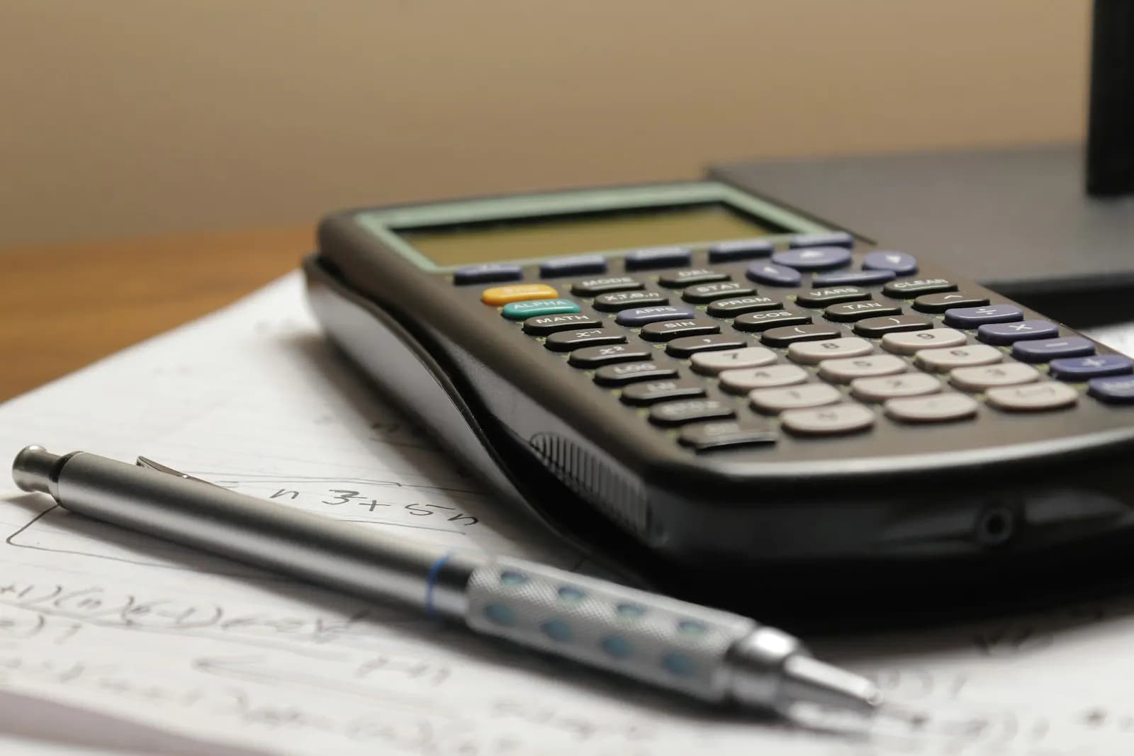 A calculator and a pen on a sheet of paper used for working out tax