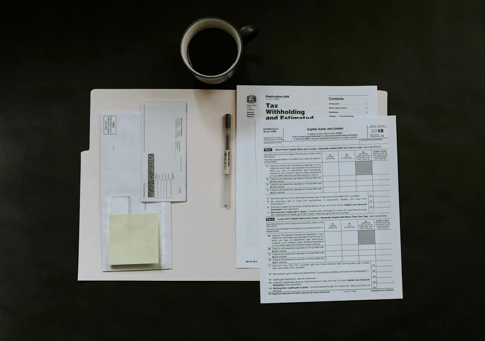 Tax forms, a pen and a coffee mug on a desk ready for reconciliation