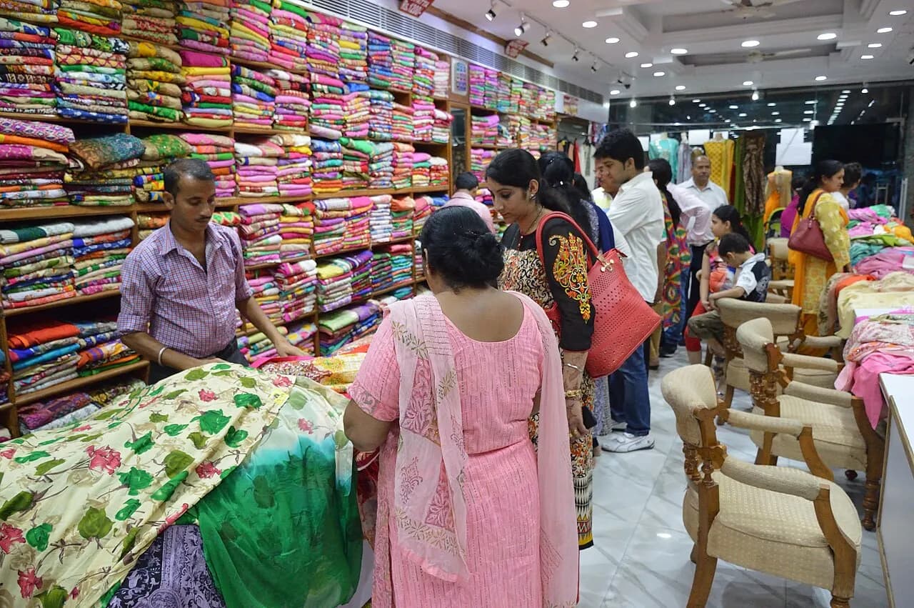 Salesmen showing fabric to customers inside a textile shop in Bridge Market, Chandigarh