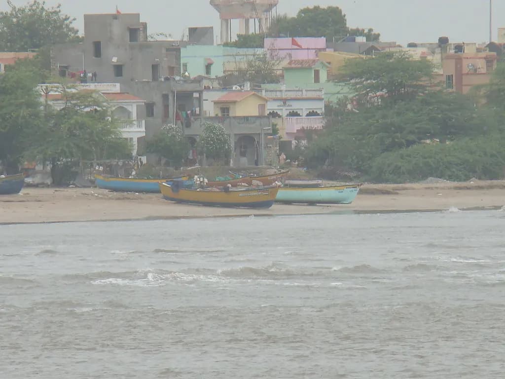 Fishing boats pulled up on the shore in front of houses in Diu