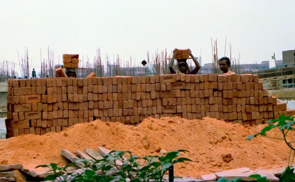 Workers carrying bricks on their heads at a construction site in New Delhi