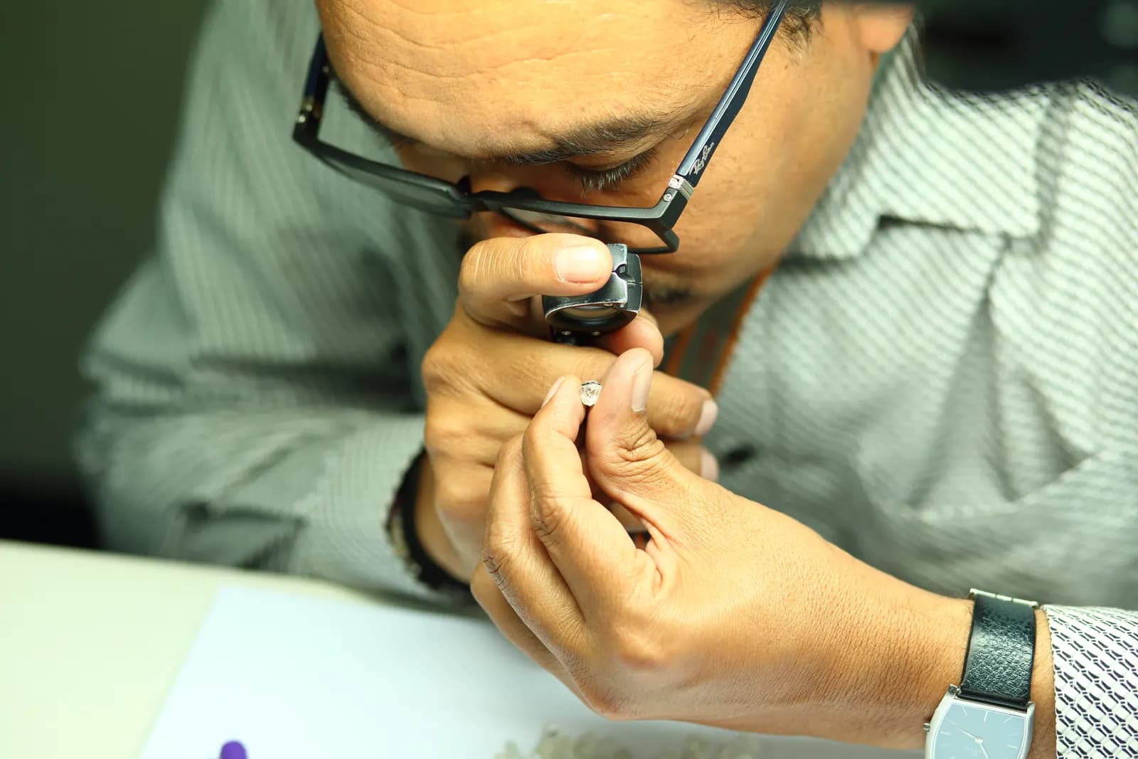 Workers checking rough diamonds for quality at a diamond-processing unit in Surat, Gujarat