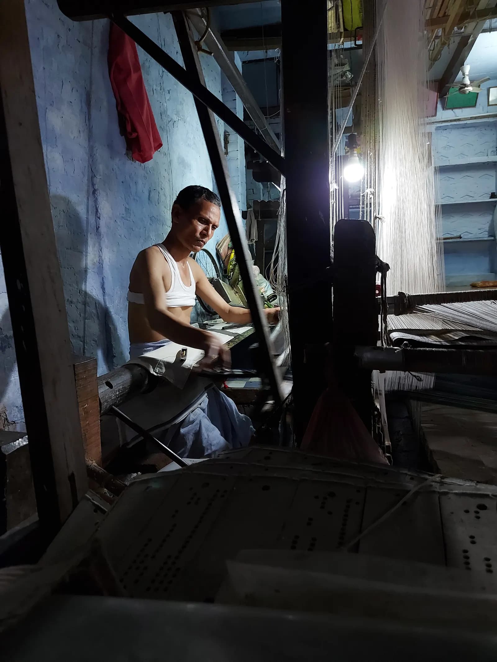 A weaver working at a handloom in a Banaras (Varanasi) workshop