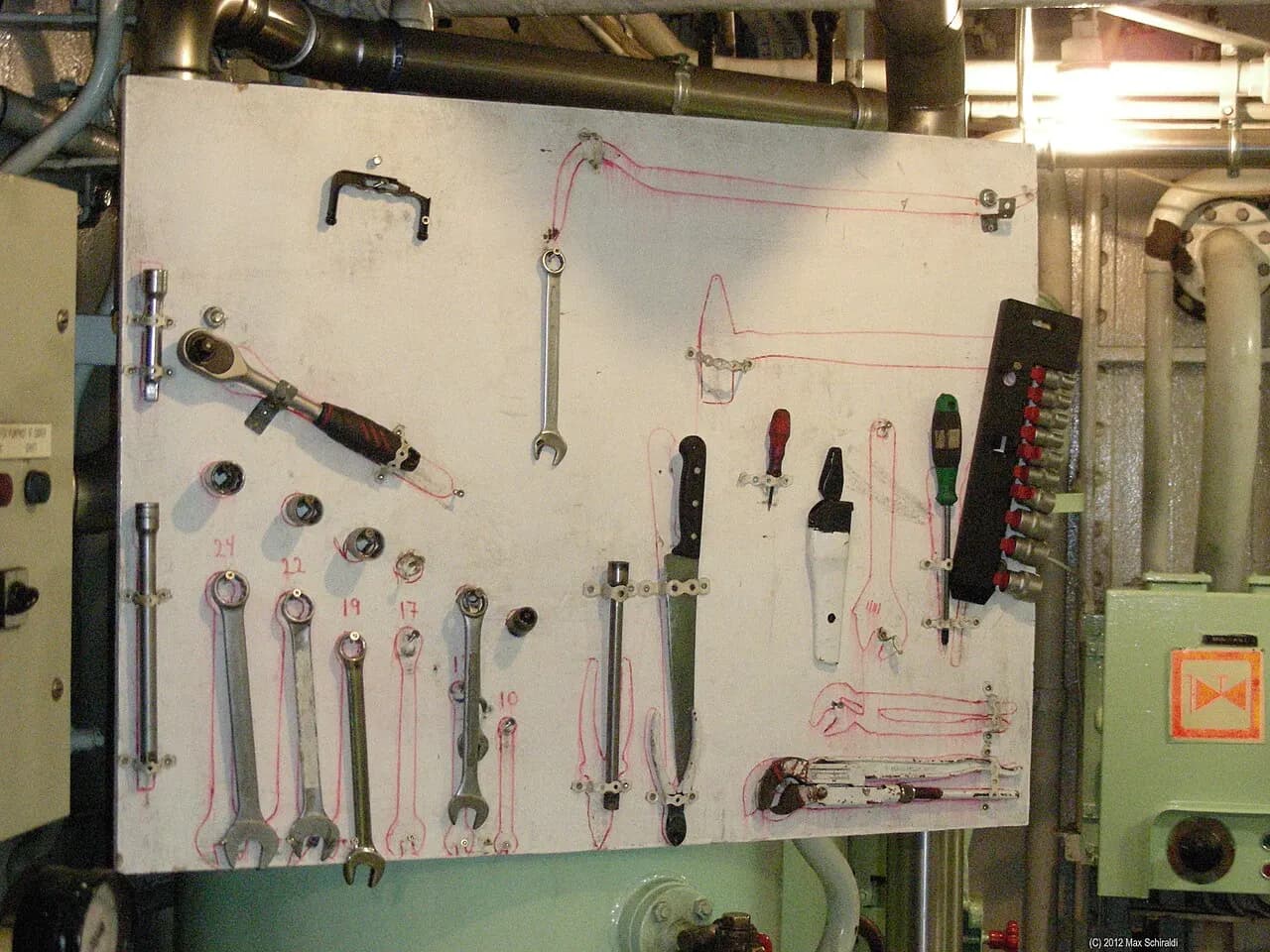 A tool shadow board with outlined spaces for each spanner and screwdriver