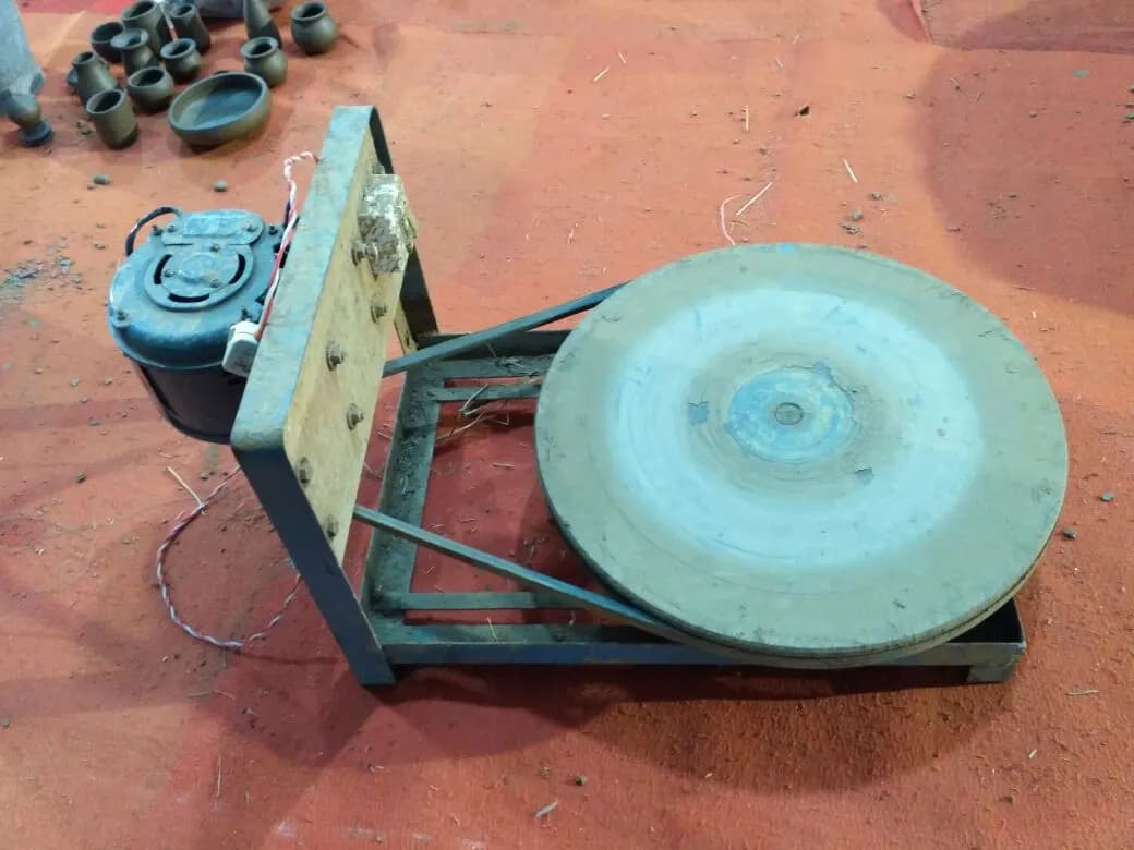 An electric potter's wheel with clay pots behind it at a craft exhibition in Bhubaneswar, Odisha