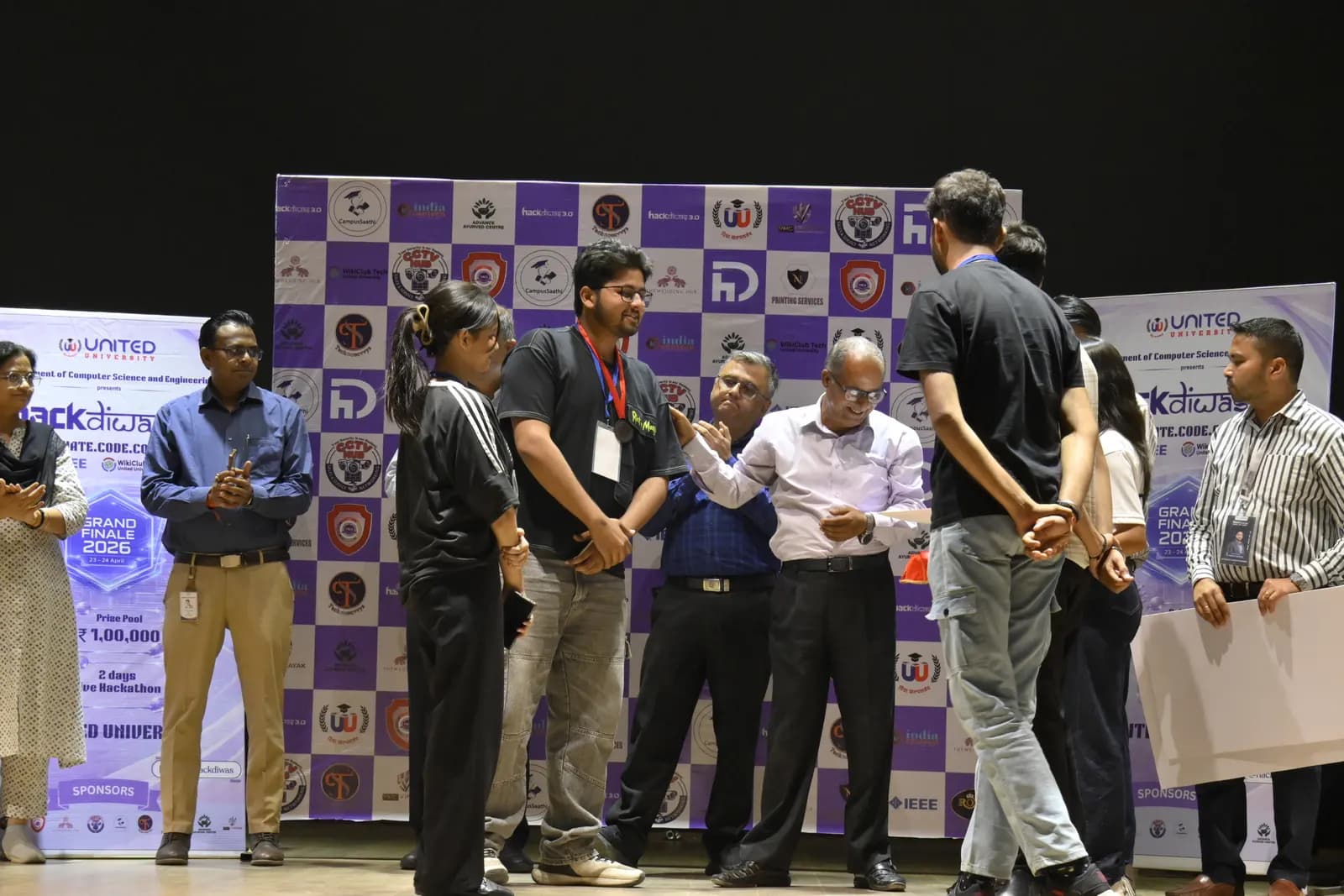 Student founders and judges on stage at a hackathon awards session in India
