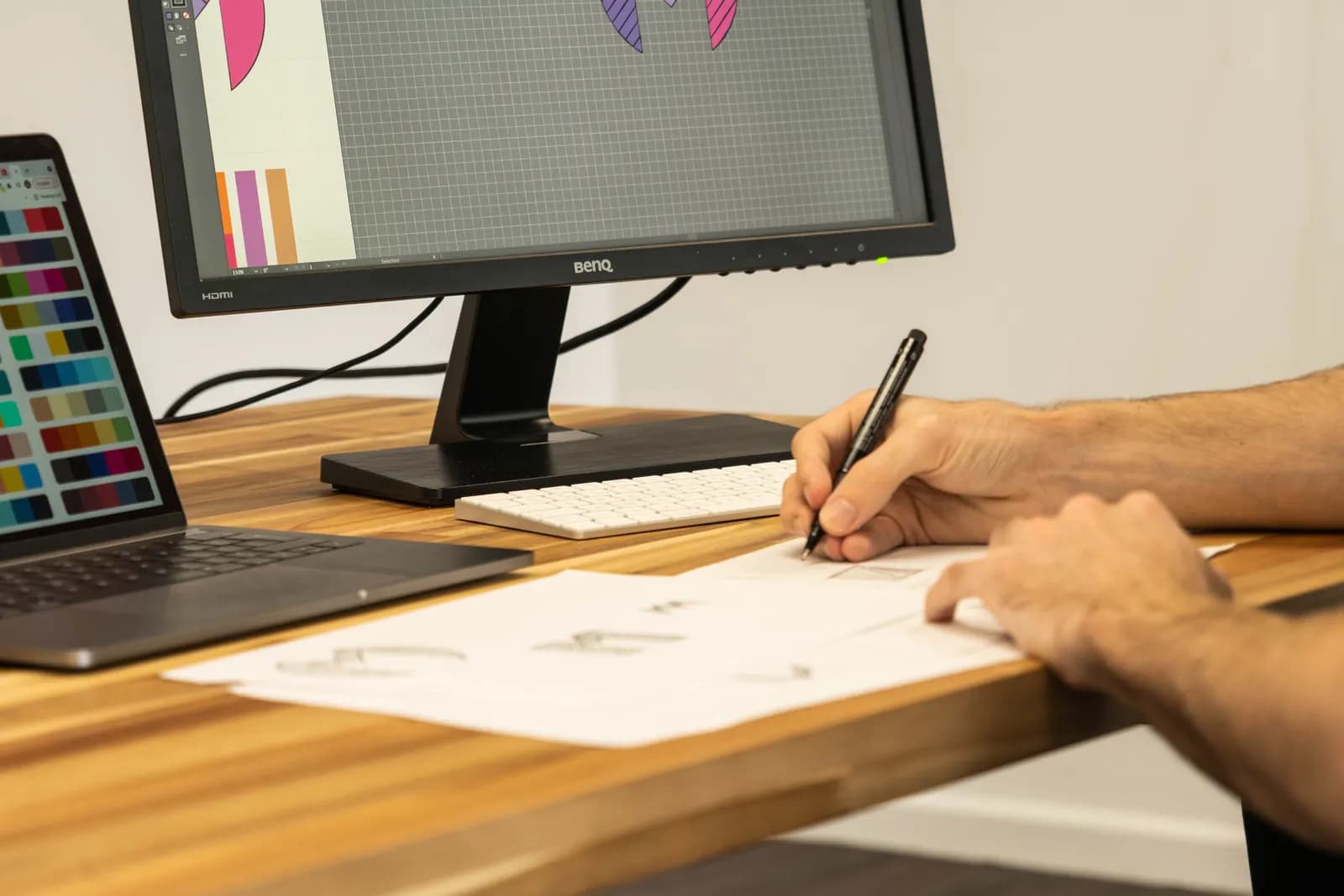 A designer sketching logo concepts in pencil on paper