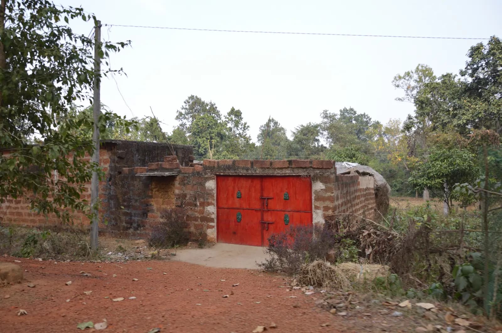 A small brick godown with red steel doors in Dhenkanal, Odisha