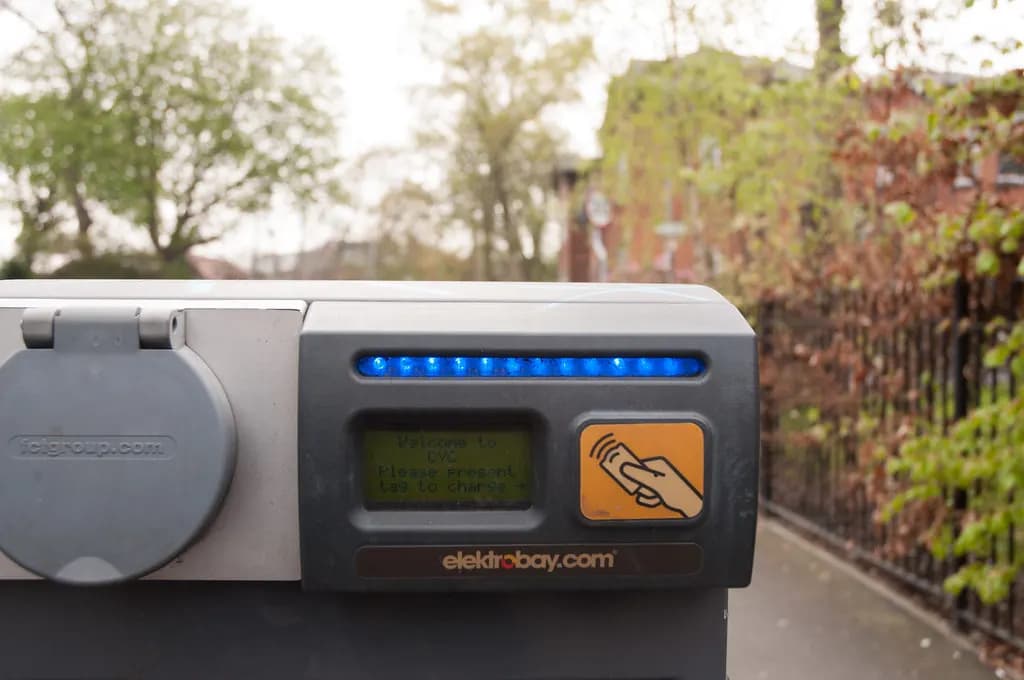 On-street electric car charging point with a socket and display panel on a suburban road