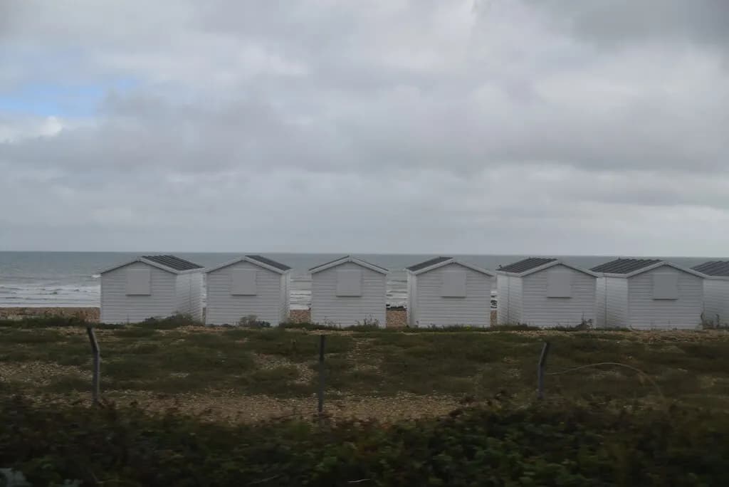 A row of white beach huts on the English coast
