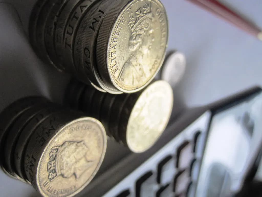 Pound coins piled beside a calculator keypad