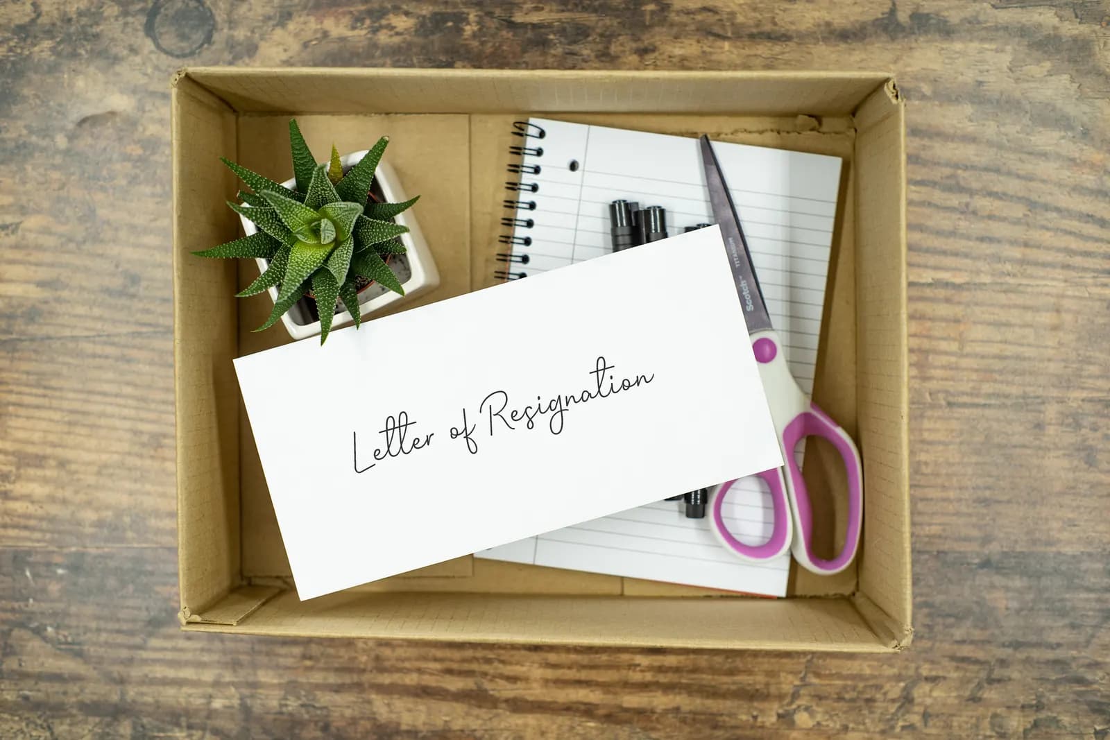 An envelope reading Letter of Resignation lying on top of a box of packed office items