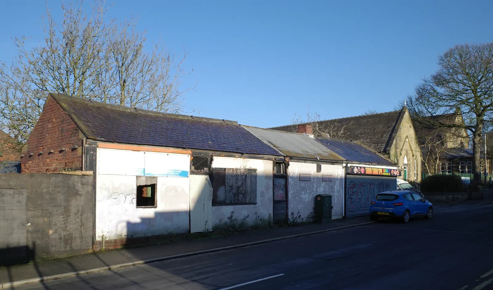 Row of closed-down single-storey shops on Vernon Road, Millbridge, Liversedge, West Yorkshire