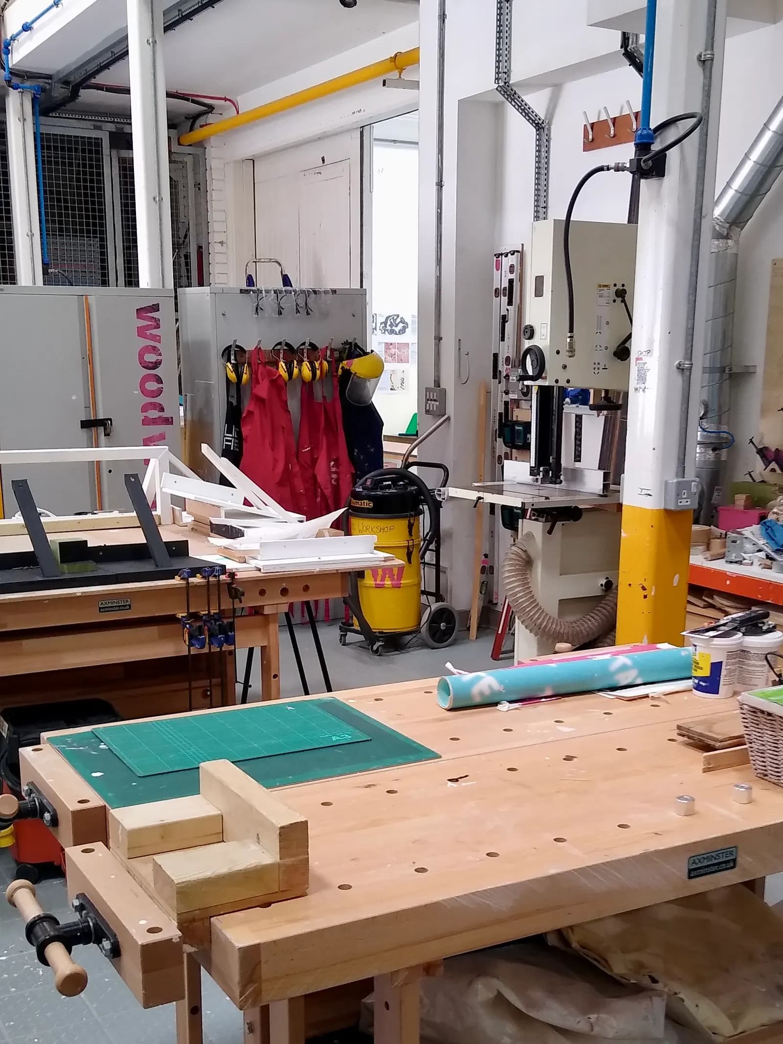 Workbenches, a band saw and dust extraction in a woodworking workshop in Farnham, Surrey