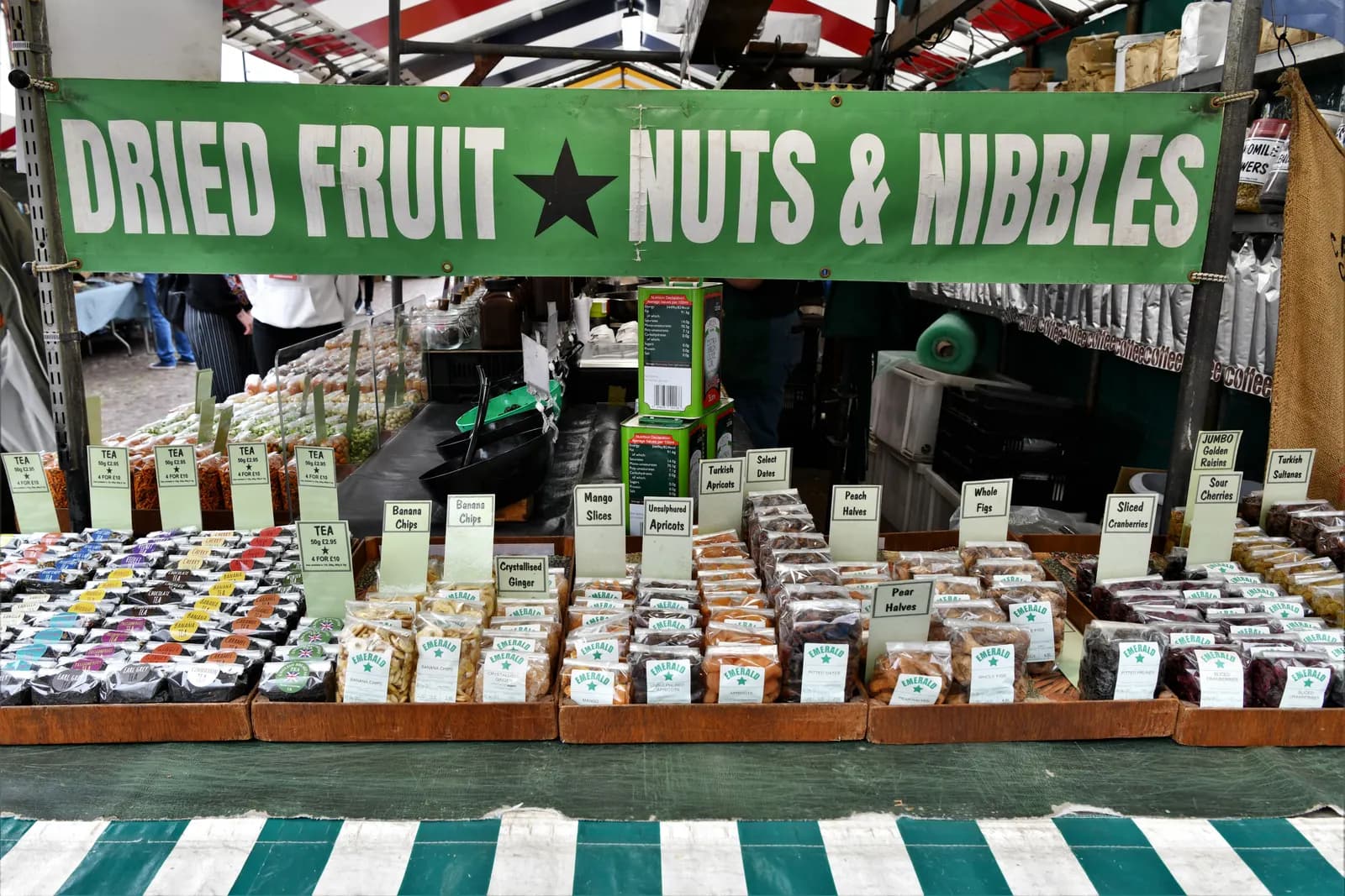 A market trader's stall in Cambridge selling dried fruit, nuts and tea in labelled bags
