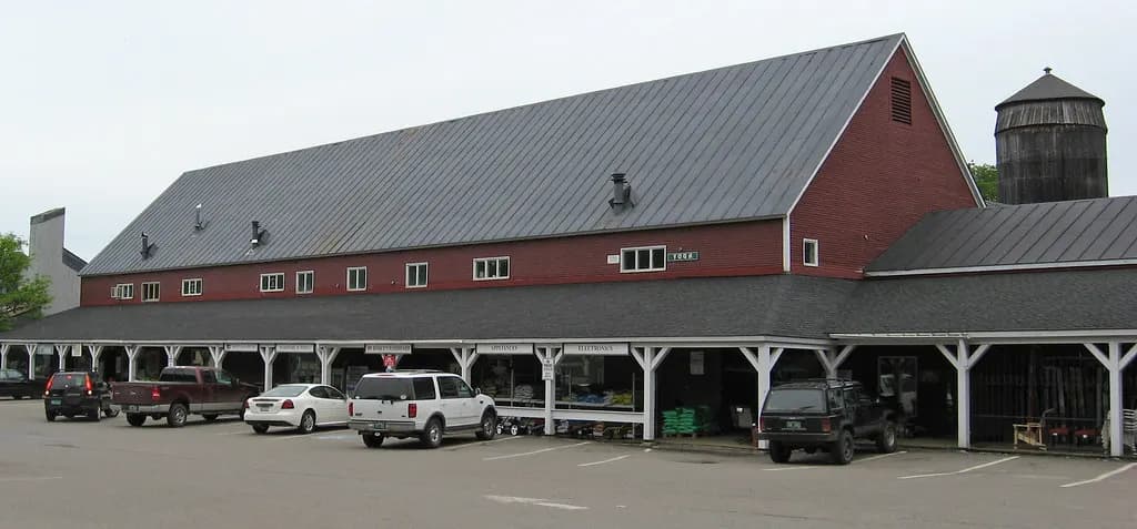 A small multi-tenant retail building with a covered walkway and parking lot in Waitsfield, Vermont