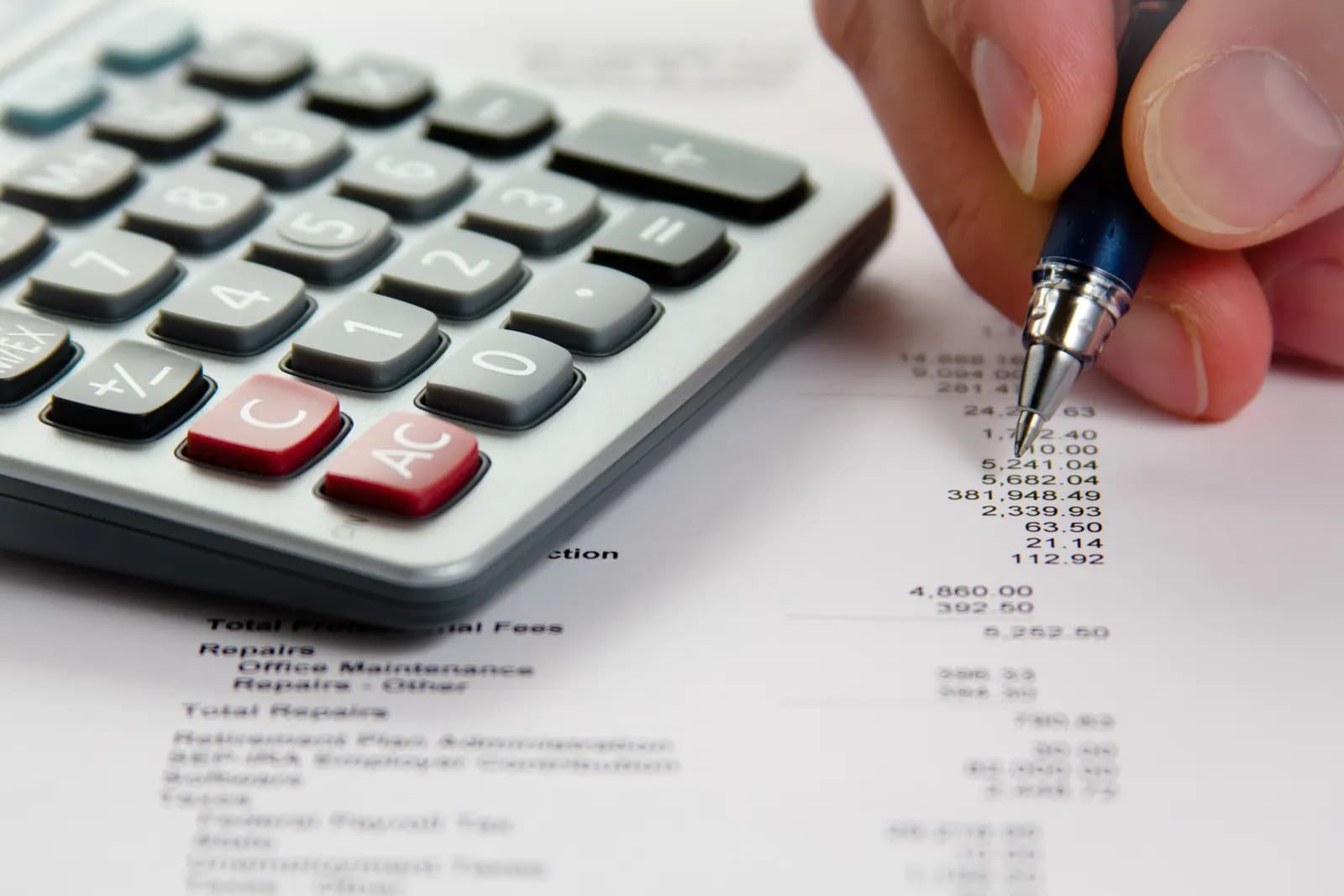 Printed financial statements with a calculator and pen on a desk, being reviewed