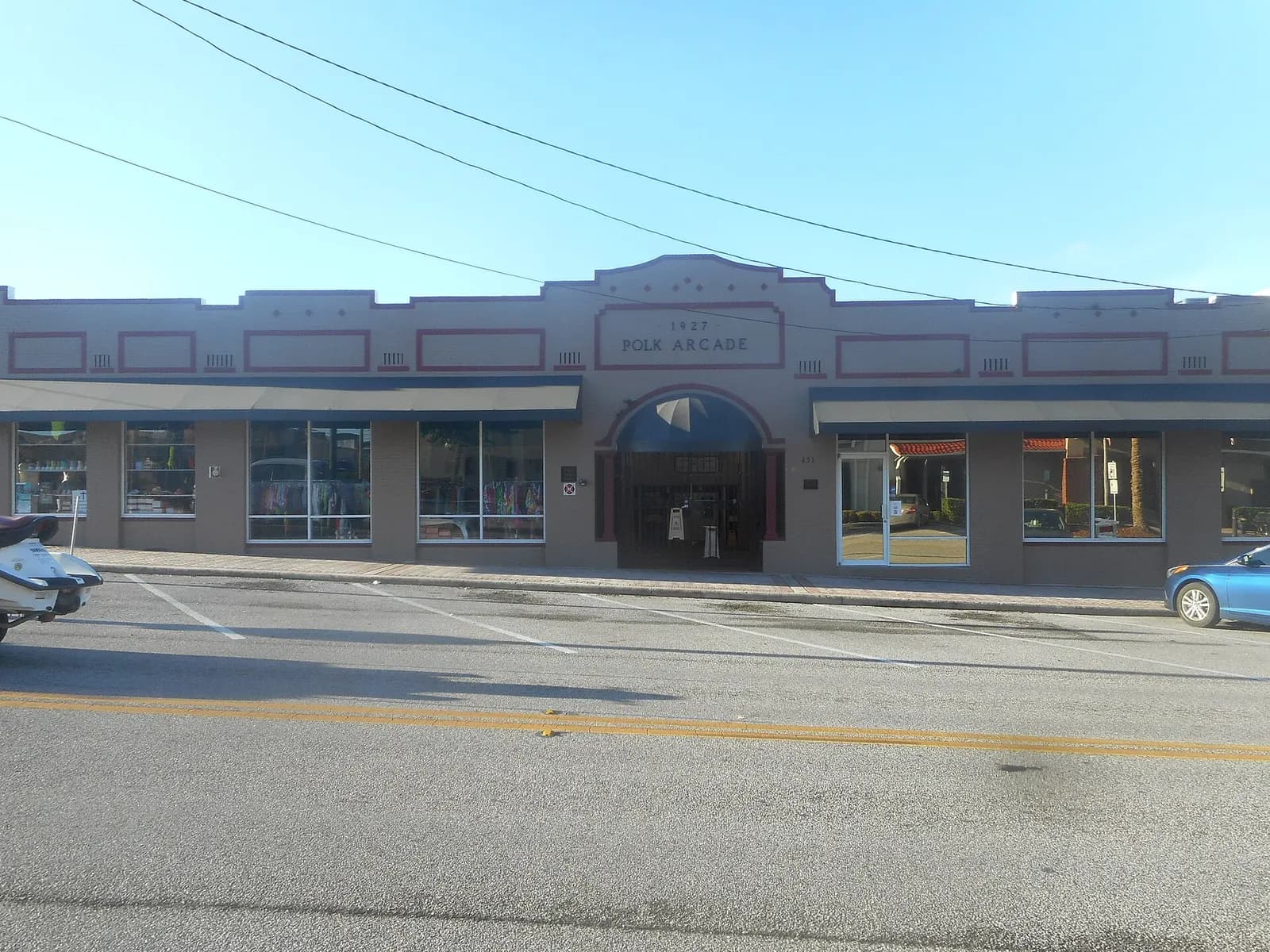 Single-storey 1927 commercial arcade with shop windows and awnings on East Main Street in Haines City, Florida
