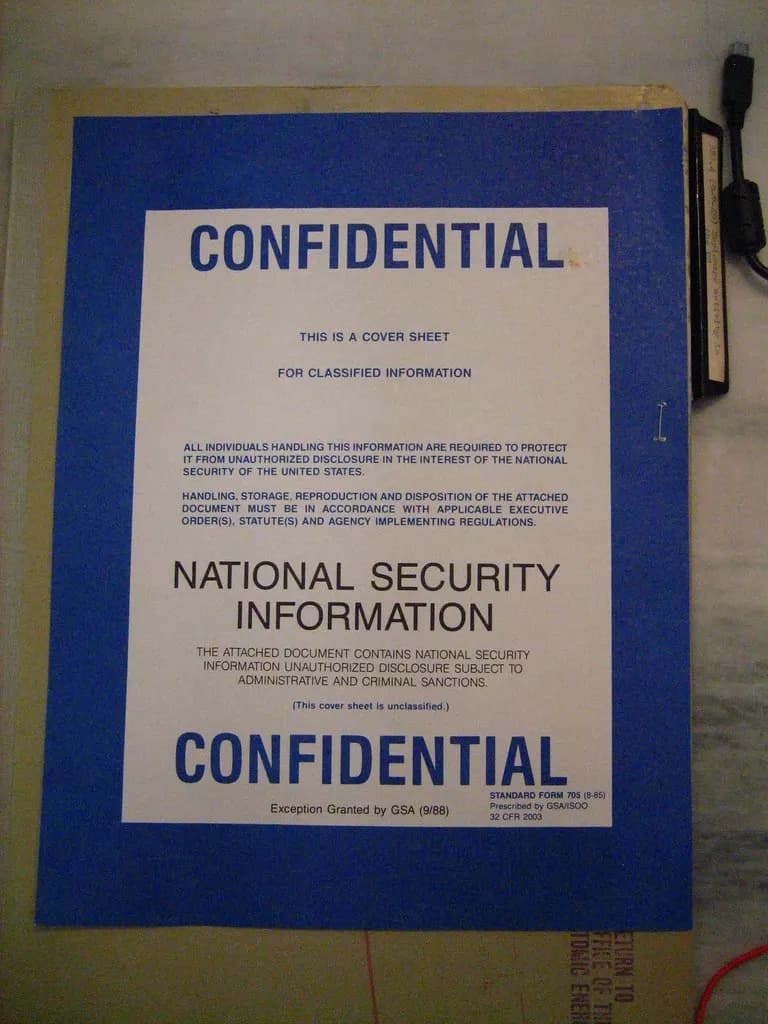 Blue and white CONFIDENTIAL cover sheet clipped to the front of a document folder