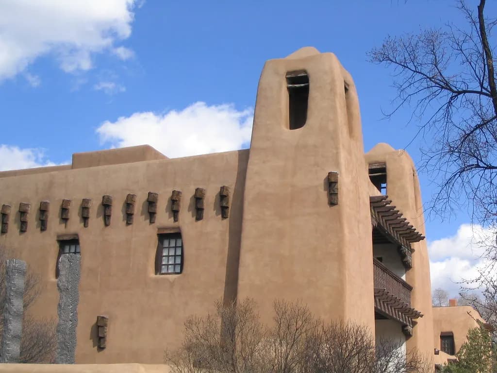 Pueblo Revival adobe building with a tower and wooden balconies in Santa Fe, New Mexico